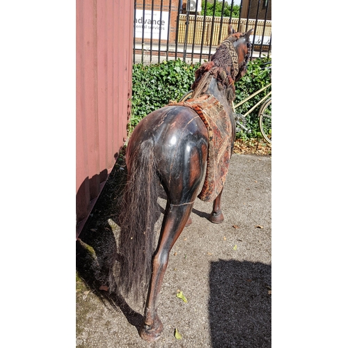 189 - A large Pakistani treen model of a horse with hand woven headstall, browband and seat, 134cm high x ... 