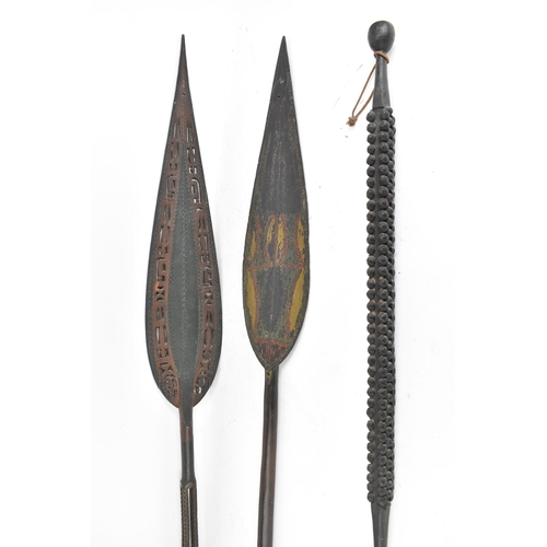 192 - Two tribal carved ceremonial paddles, each with an elongated leaf shape paddle, 161cm high and 158cm... 