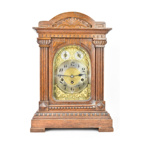 47 - A circa 1900 oak cased mantle clock, the case of architectural form with an arched top, dental mould... 