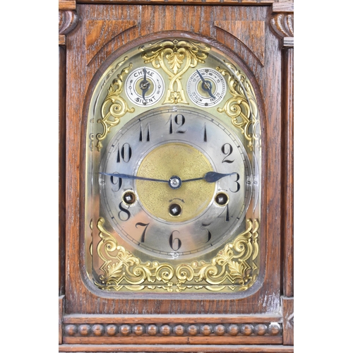 47 - A circa 1900 oak cased mantle clock, the case of architectural form with an arched top, dental mould... 