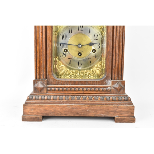 47 - A circa 1900 oak cased mantle clock, the case of architectural form with an arched top, dental mould... 