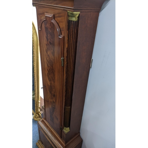 50 - An early 19th century mahogany 8 day longcase clock, having an arched top with pierced grille above ... 