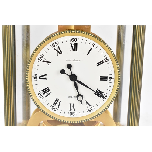 76 - A Jaeger LeCoultre Atmos clock, in a gilt brass case with reeded columns flanking the circular white... 