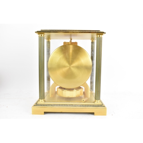 76 - A Jaeger LeCoultre Atmos clock, in a gilt brass case with reeded columns flanking the circular white... 