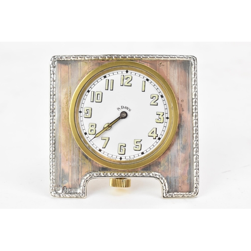 82 - An early 20th century silver 8 day bedside travel clock, the white enamel dial having luminous Arabi... 