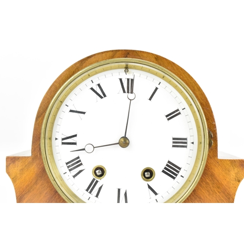 84 - An early 20th century walnut 8 day mantle clock, the white enamel dial having black Roman numerals w... 