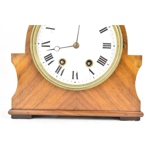 84 - An early 20th century walnut 8 day mantle clock, the white enamel dial having black Roman numerals w... 