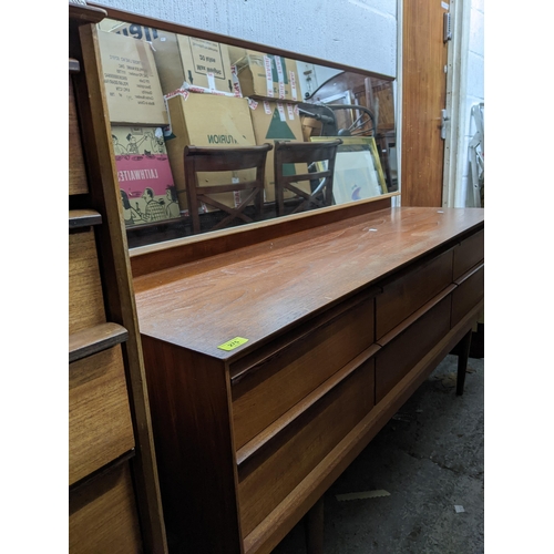 275 - A mid-century teak dressing table with mirror, possibly Austinsuite, the base with six short drawers... 