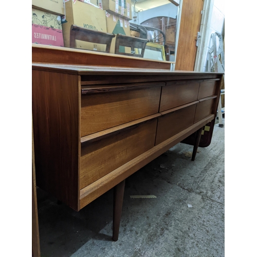 275 - A mid-century teak dressing table with mirror, possibly Austinsuite, the base with six short drawers... 