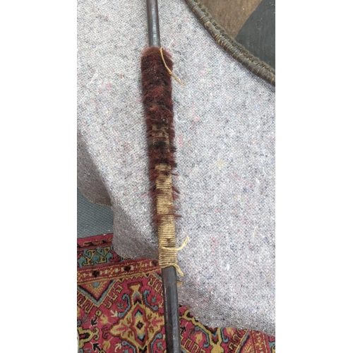 349 - A vintage Masai painted leather shield with a wooden handle, and two African spears, one part wooden... 