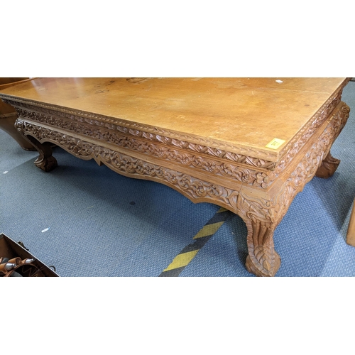 377 - A Chinese coffee table having an ornate carved border, shaped apron and on short cabriole legs, 41.5... 