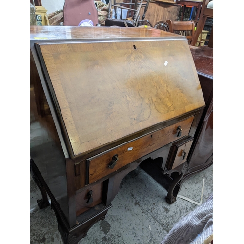 276 - A 1920s Queen Anne style bureau with fall flap open pigeonholes and short drawers with one long draw... 