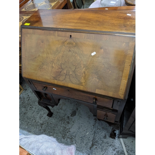 276 - A 1920s Queen Anne style bureau with fall flap open pigeonholes and short drawers with one long draw... 