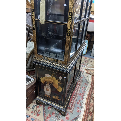 516 - A late 20th century Chinese style black and gilt cabinet with an arched top, over twin glazed doors ... 