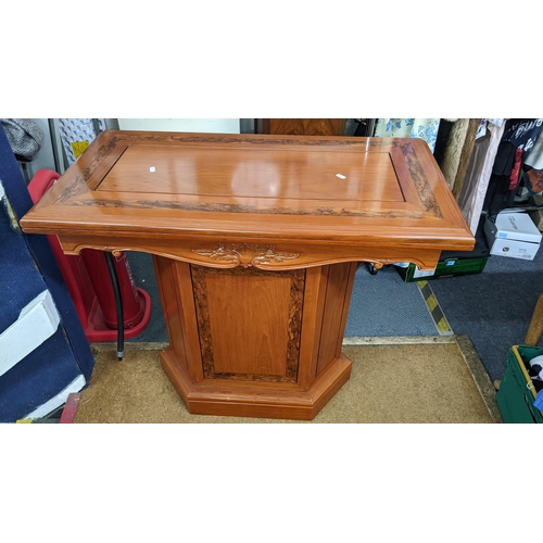 381 - An Indonesian hardwood foldover games table having a swivel top on a pedestal base with a single cup... 