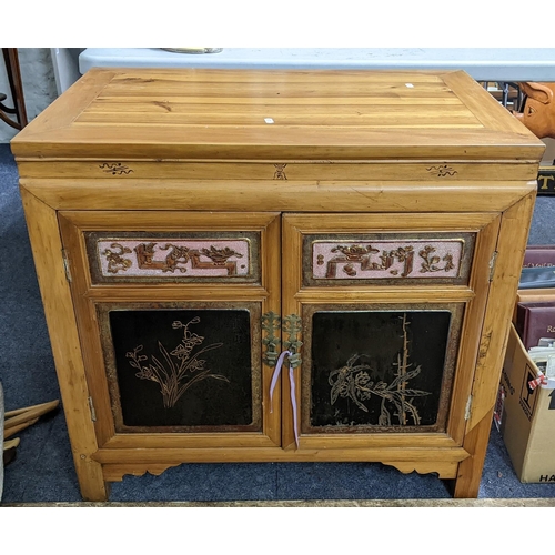 389 - A Chinese pine cabinet having two panelled doors opening to reveal three fitted drawers, 72.5cm h x ... 