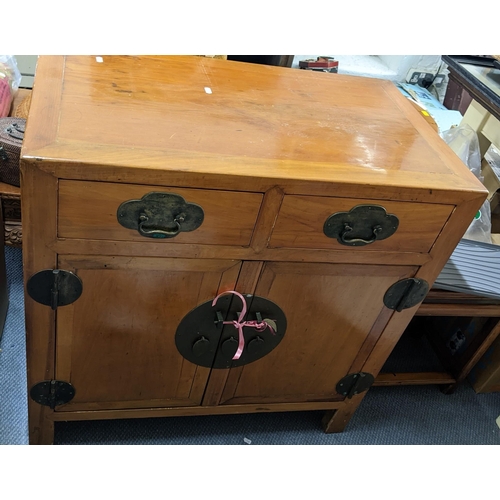 390 - A Chinese light elm cabinet having two drawers above cupboard doors with brass fixings, 87cm h x 86.... 