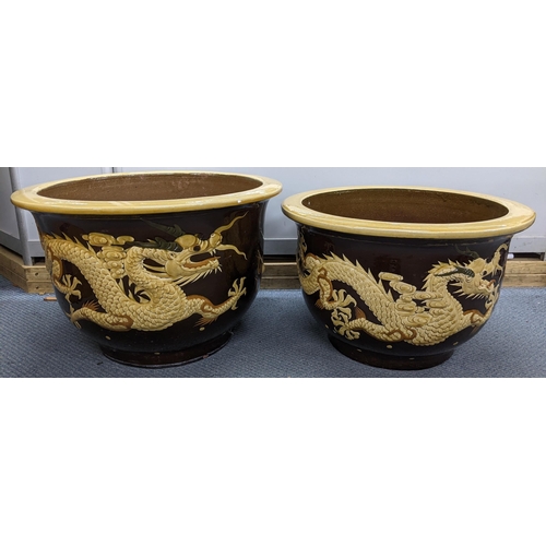 424 - Two reproduction earthenware relief moulded planters, decorated with Chinese dragons, the largest 33... 