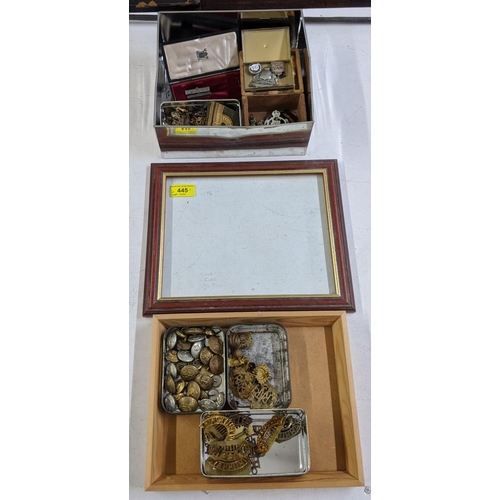 445 - Military cap badges and buttons and regiment name badges, along with a table top display case (glass... 