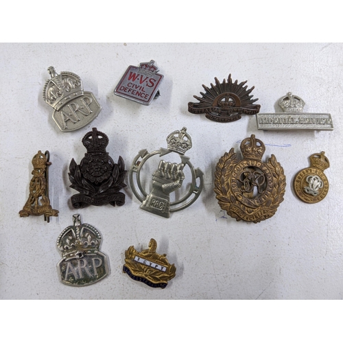 445 - Military cap badges and buttons and regiment name badges, along with a table top display case (glass... 