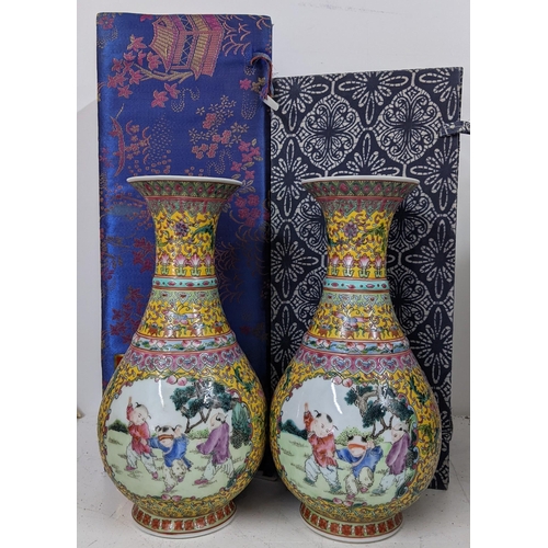 454 - A pair of 20th century Chinese famille rose baluster porcelain vases, each having panels painted wit... 