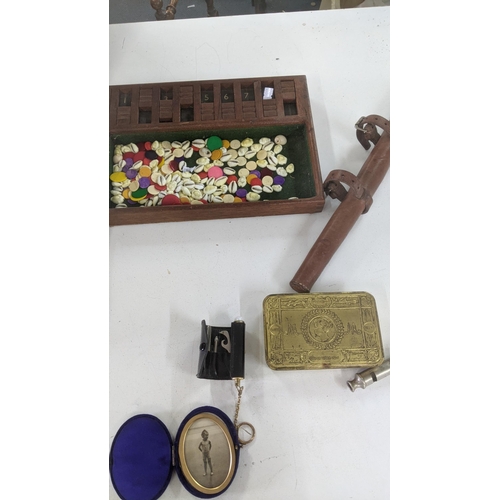 489 - A mixed lot to include a WWI British Army 1915 trench whistle, a WWI Princess Mary Christmas tin, a ... 