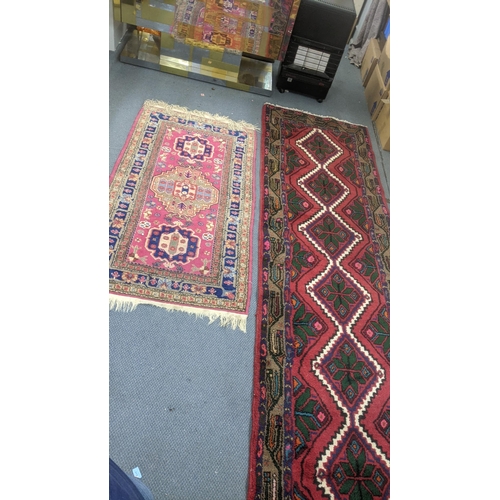 553 - Two handwoven rugs to include a Turkish red ground runner having floral motifs, 300cm x 86cm, the ot... 