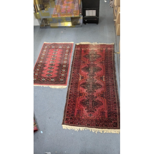 555 - Two handwoven rugs to include an Afghan rug on a red ground with repeating motifs, 205 x 95cm, the o... 