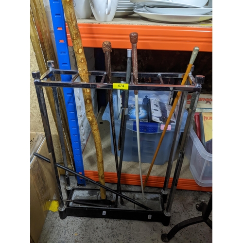 474 - A chrome plated and cast iron stick stand containing a wooden rustic walking stick, various riding c... 