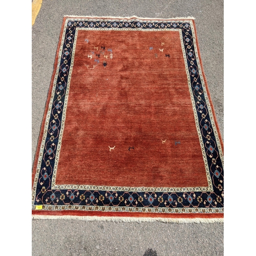 533 - A contemporary Persian hand woven rug having a red ground with triple guard and cream borders, 198 x... 