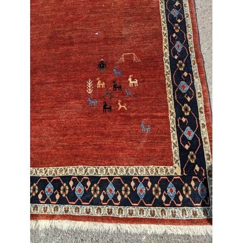 533 - A contemporary Persian hand woven rug having a red ground with triple guard and cream borders, 198 x... 