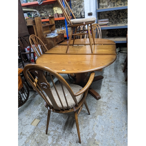 543 - A late 20th century Ercol elm extending dining table with butterfly extending leaf, on pedestal base... 