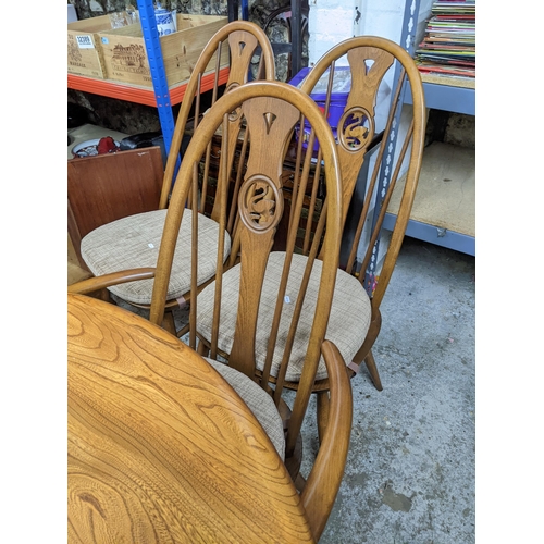 543 - A late 20th century Ercol elm extending dining table with butterfly extending leaf, on pedestal base... 