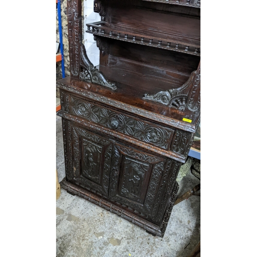 279 - A late 18th century carved oak cabinet with stepped moulded cornice, balustrade decoration, scrolled... 