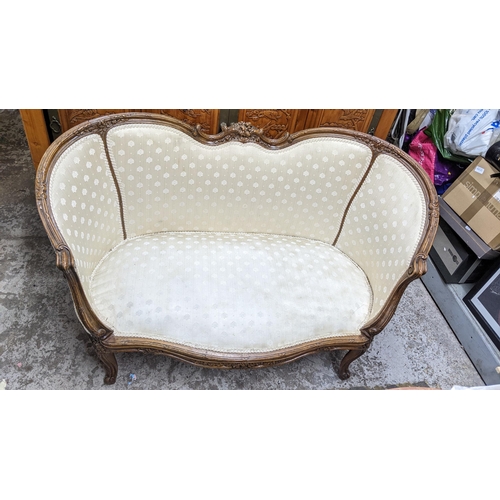 523 - A French walnut matched three-piece salon suite upholstered in a cream floral fabric, the two seater... 