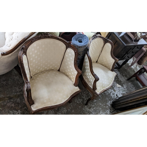 523 - A French walnut matched three-piece salon suite upholstered in a cream floral fabric, the two seater... 