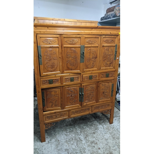 535 - A 20th century Chinese light wood side cabinet with carved decoration and fretwork spandrels, 177 x ... 