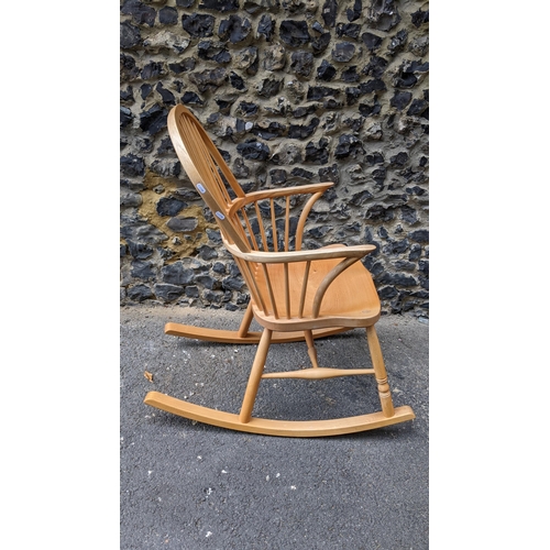 197 - A Stewart Linford Windsor ash, elm and beech stick back rocking chair, in the Ercol style, having a ... 