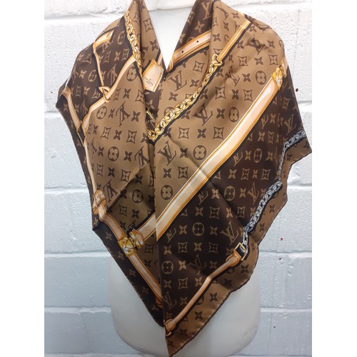 2 - Louis Vuitton- A brown LV monogram silk scarf with belt and chain design having hand rolled edges to... 