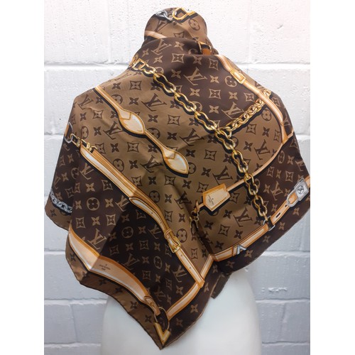 2 - Louis Vuitton- A brown LV monogram silk scarf with belt and chain design having hand rolled edges to... 