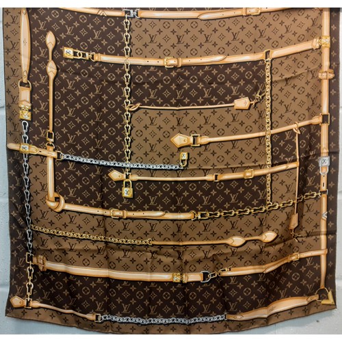 2 - Louis Vuitton- A brown LV monogram silk scarf with belt and chain design having hand rolled edges to... 