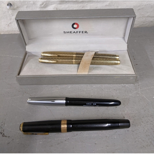 11 - Four pens to include a boxed 14ct gold plated Shaefer fountain and ball point pen set together with ... 