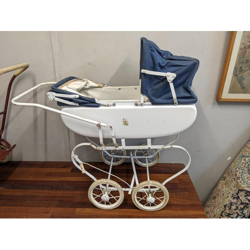 115 - Two 1960's dolls prams, one white with decoration on the side with a canopy and the other dark red w... 