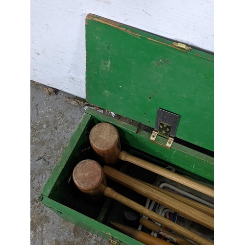 119 - A mid 20th century croquet set comprising four mallets, four balls, a selection of hoops, a croquet ... 