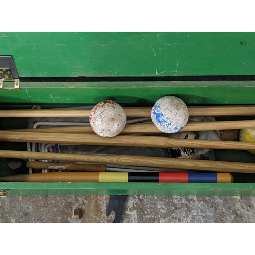 119 - A mid 20th century croquet set comprising four mallets, four balls, a selection of hoops, a croquet ... 