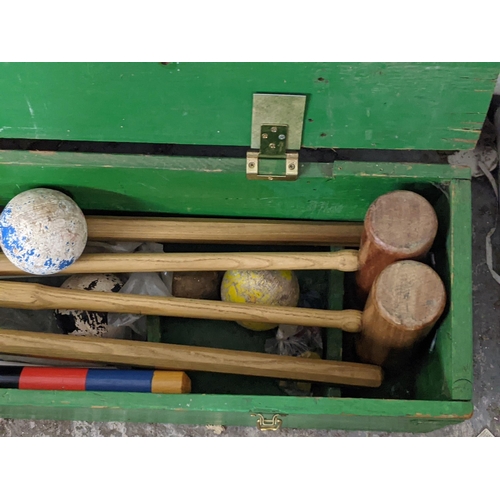 119 - A mid 20th century croquet set comprising four mallets, four balls, a selection of hoops, a croquet ... 