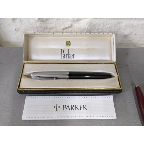 12 - A collection of pens to include a boxed Parker 51 fountain pen, a boxed Parker 41 fountain pen and t... 