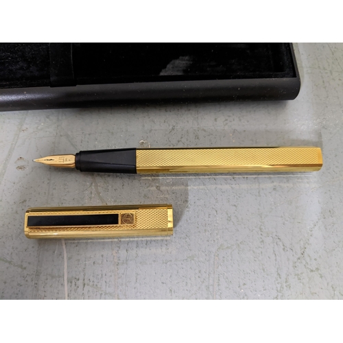 18 - A Dunhill gold coloured fountain pen with an 14t gold nib and a cross gold coloured ball point house... 