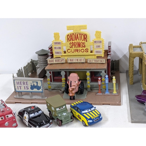 126 - A Disney Cars set with a set imitating Radiator Springs with various characters to include Lightning... 