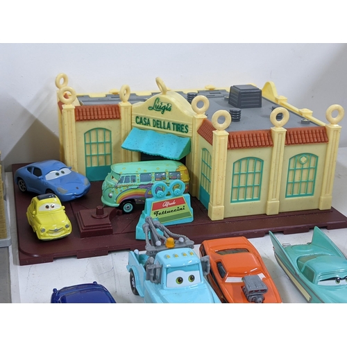 126 - A Disney Cars set with a set imitating Radiator Springs with various characters to include Lightning... 